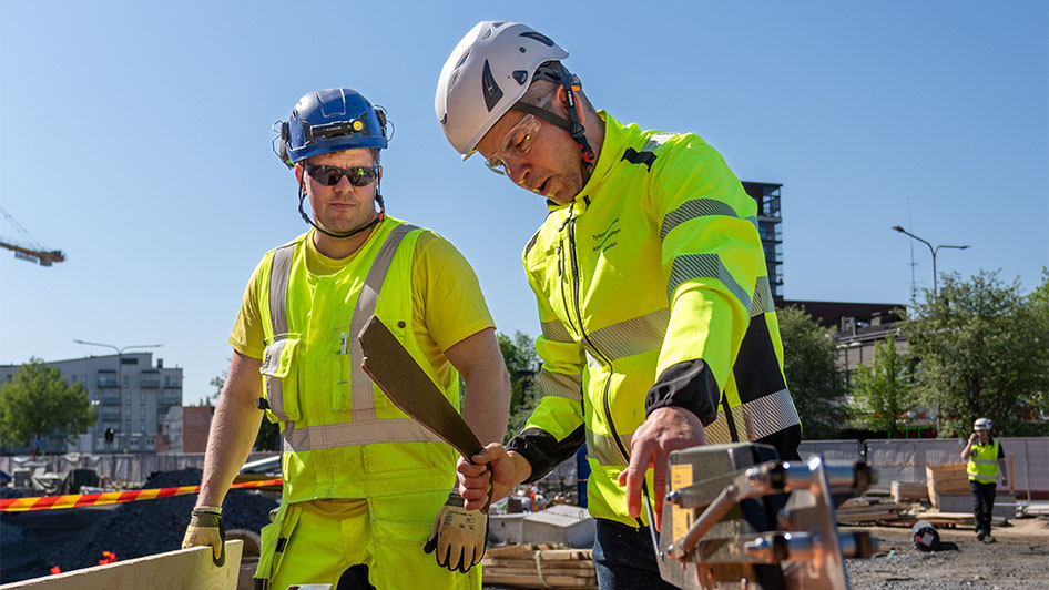 Kaksi henkilöä rakennustyömaalla.