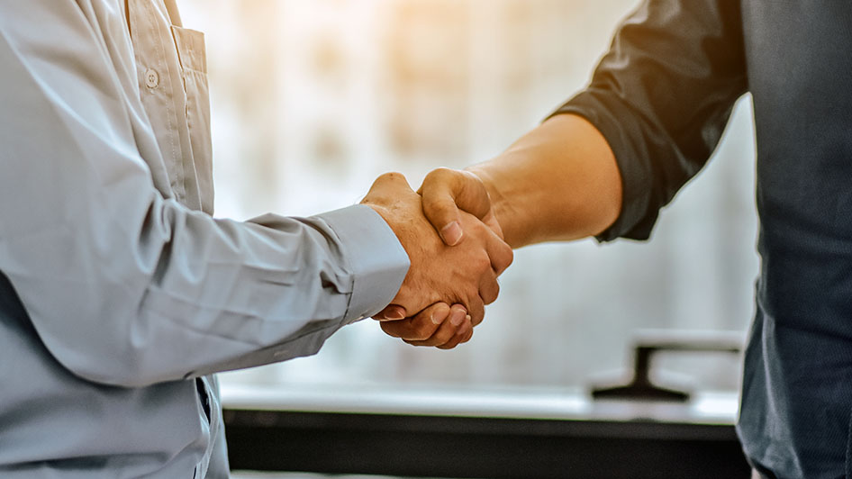 Kaksi henkilöä kättelee.