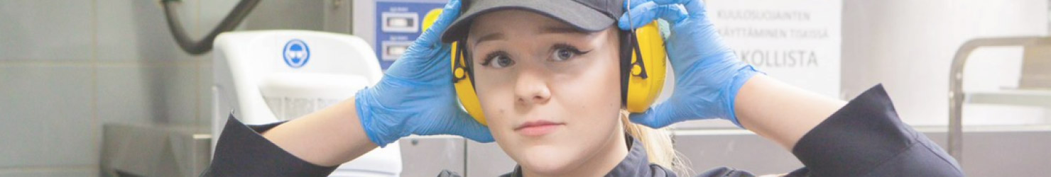 A worker putting on hearing protection