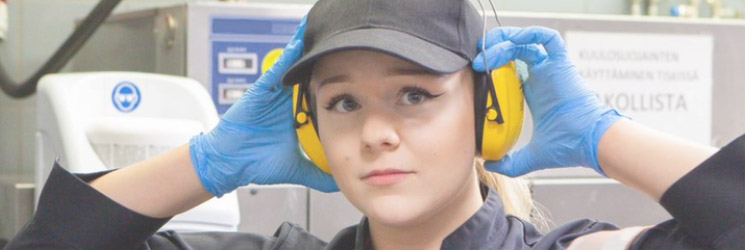 A worker putting on hearing protection